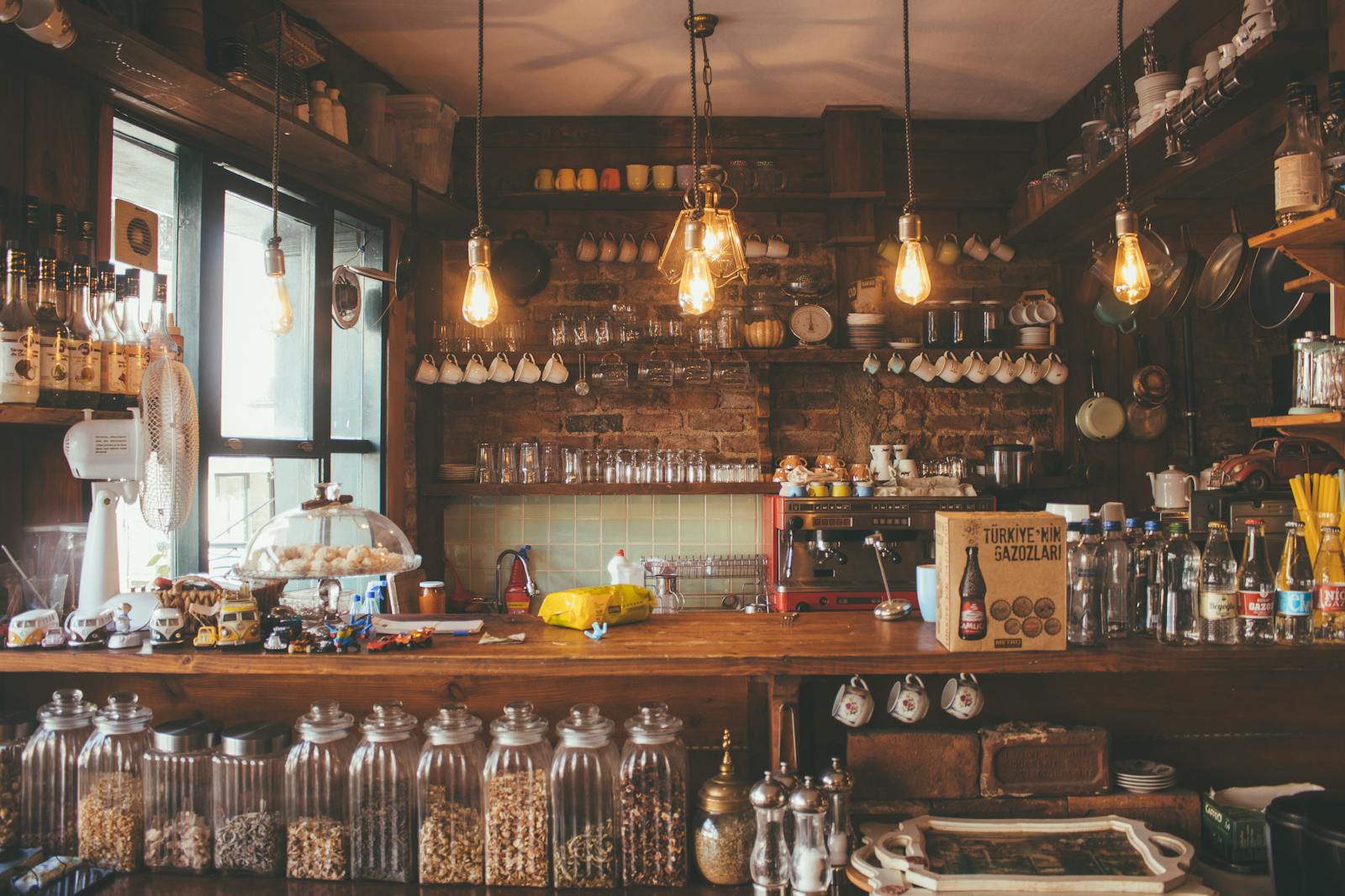 business A cozy cafe with rustic decor, pendant lights, and glass jars creates a vintage ambiance.