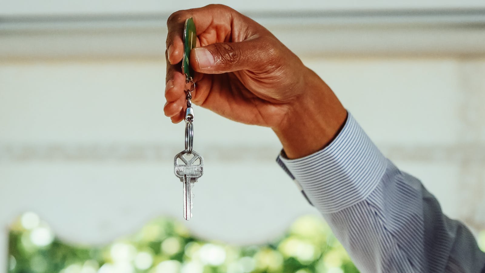 renters A hand holding a set of house keys, symbolizing buying or renting a new home.